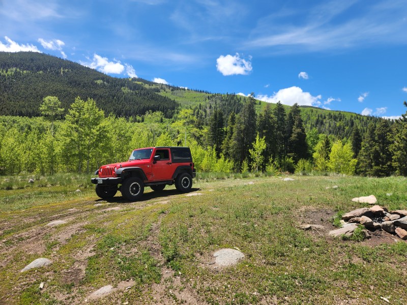 Jeep parked in a green Colorado mountain meadow